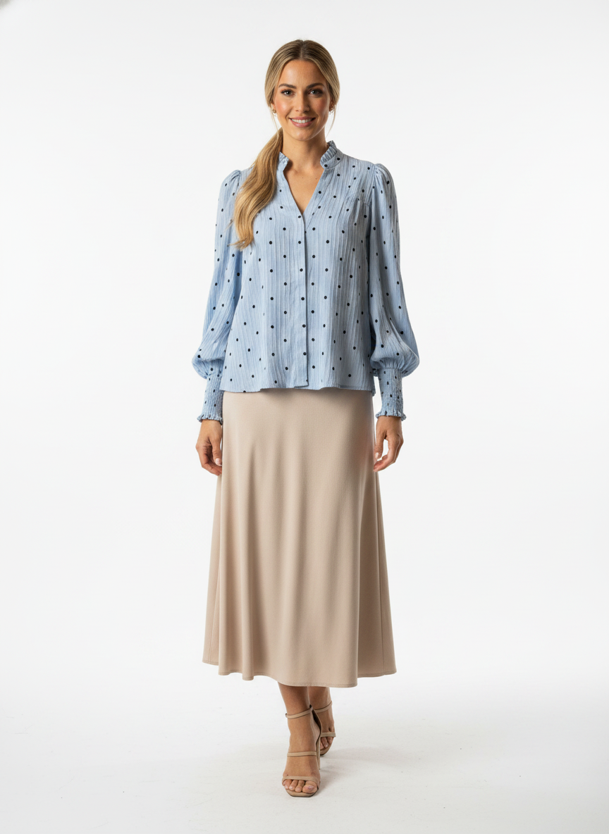 Model i lyseblå prikket skjorte med flæsekrave og pof-ærmer – step skirt