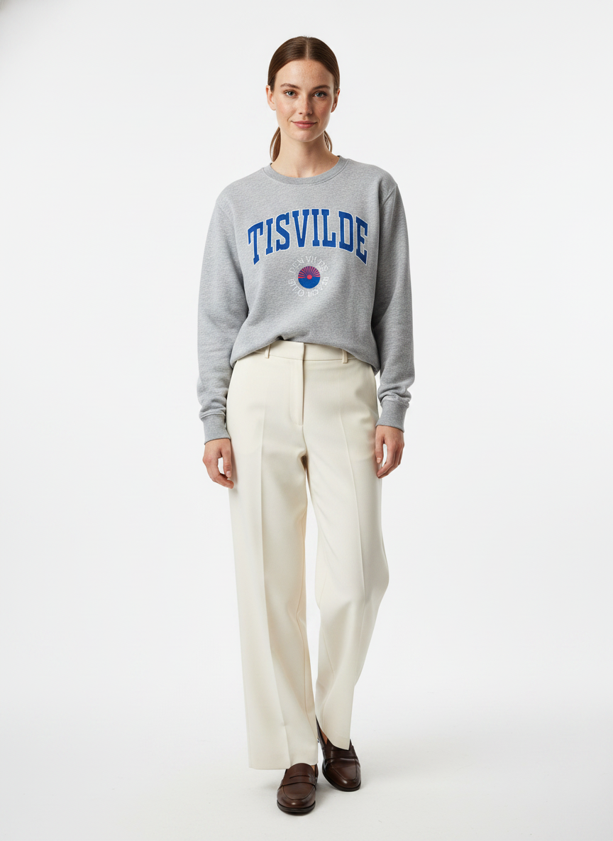 Model i lysegrå sweatshirt med tisvilde-college print – step trousers