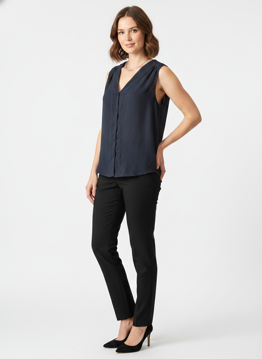 Model i mørkeblå ærmeløs bluse med knaplukning – threequarter trousers blazer