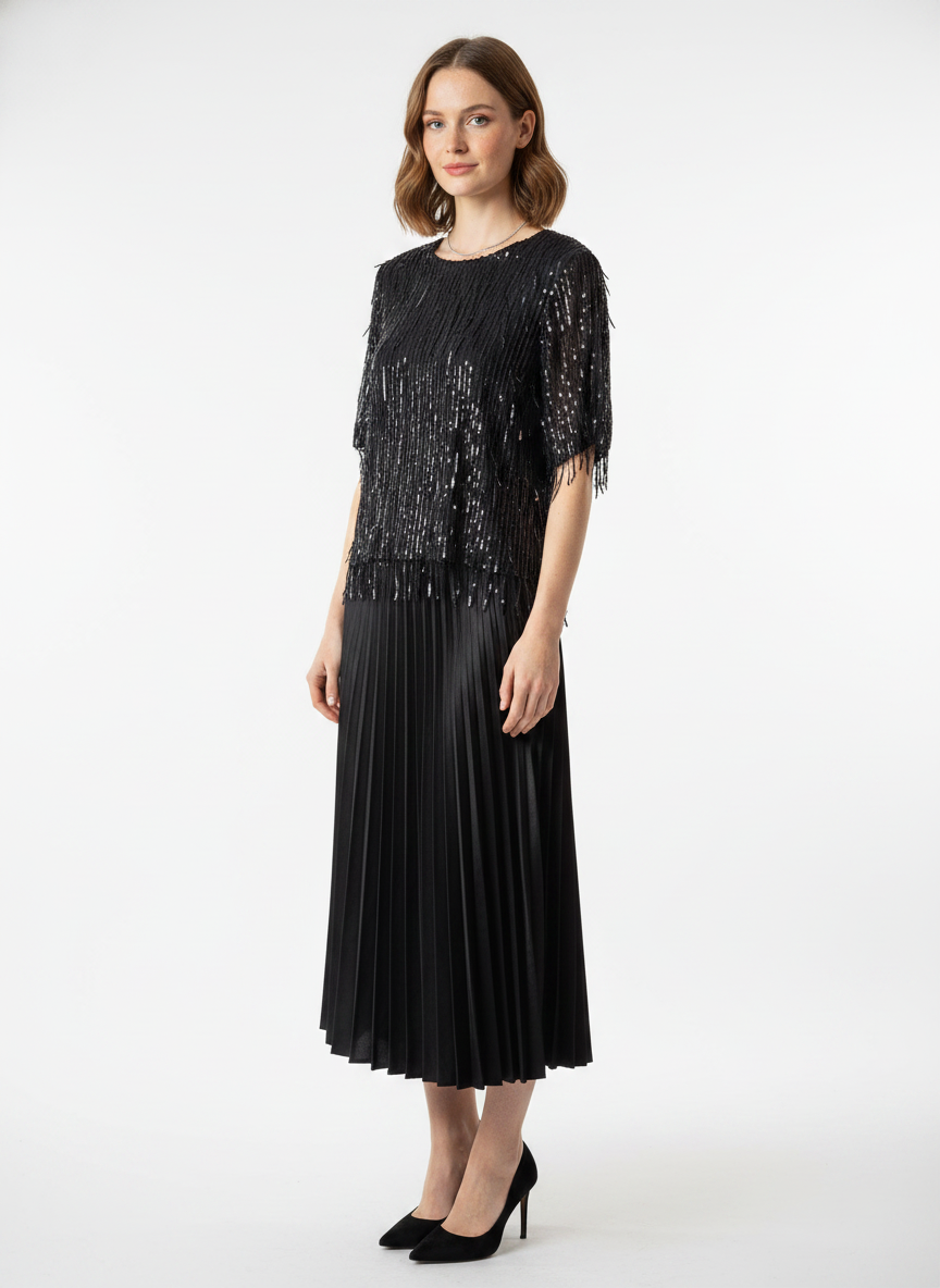 Model i sort bluse med hængende paillet-fringes – threequarter skirt