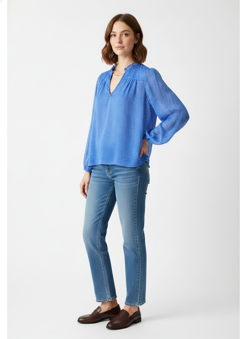 Model i klar blå bluse med glimmer-striber og flæsekrave – threequarter jeans loafers