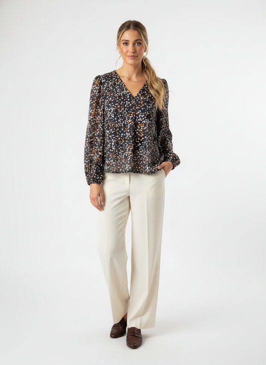 Model i mørk småblomstret bluse med v-udskæring – step trousers
