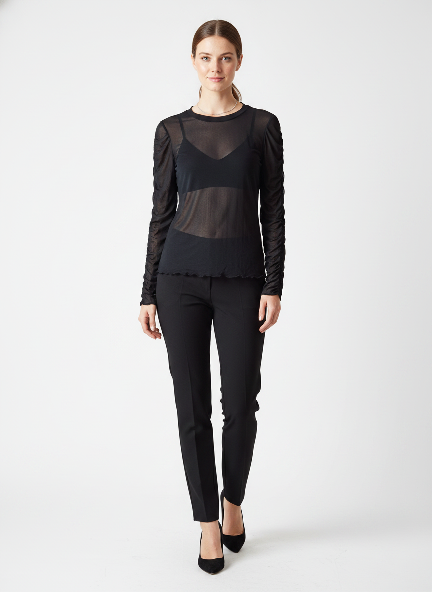 Model i sort gennemsigtig bluse med ruched ærmer – step trousers