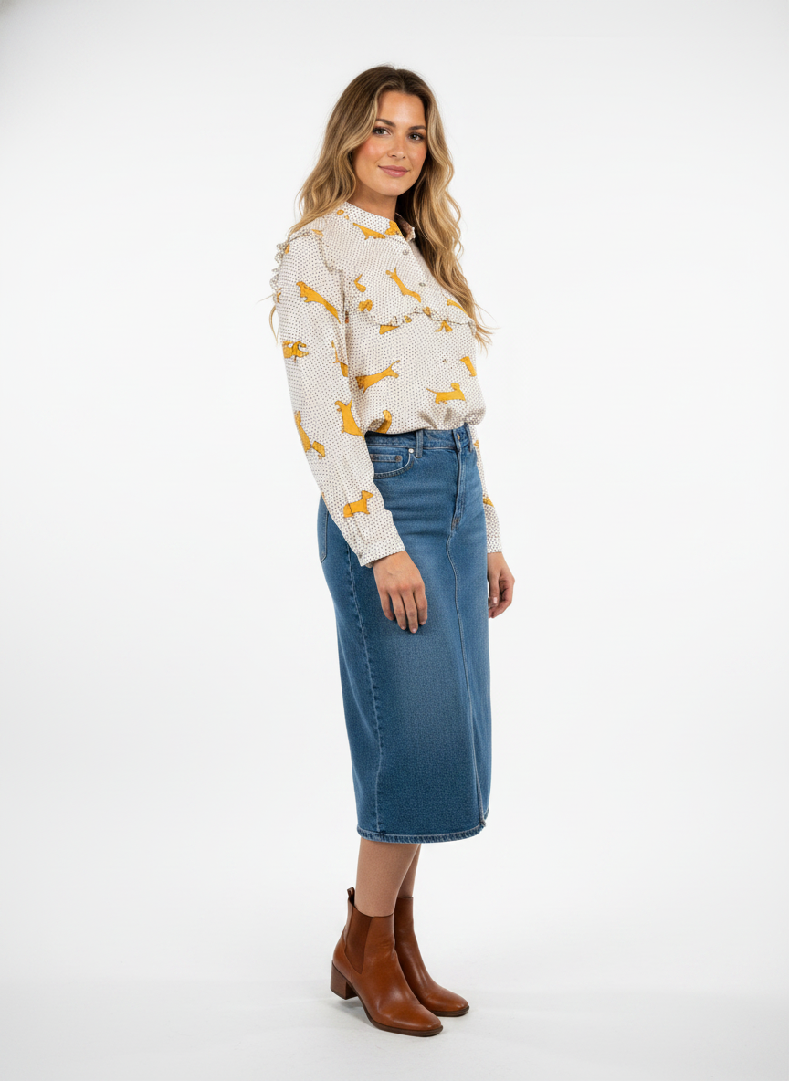 Model i cremehvid skjorte med gravhunde-print og flæsedetalje – threequarter skirt