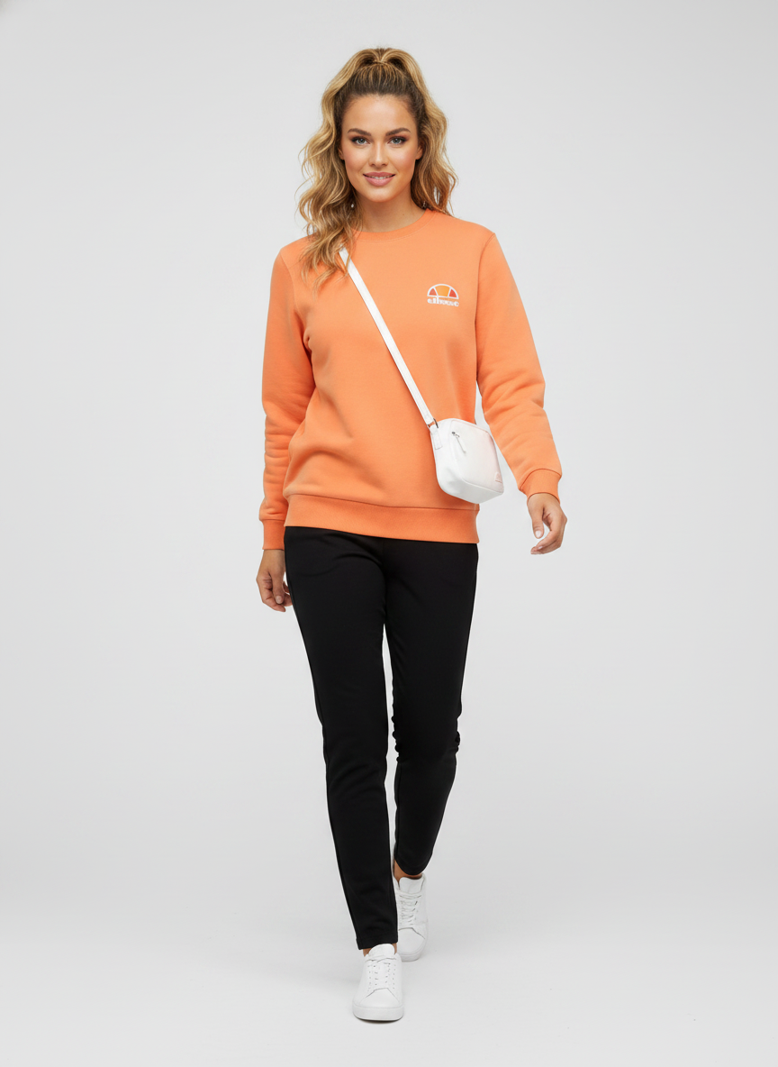 Model i orange sweatshirt med klassisk crewneck – styling: athleisure