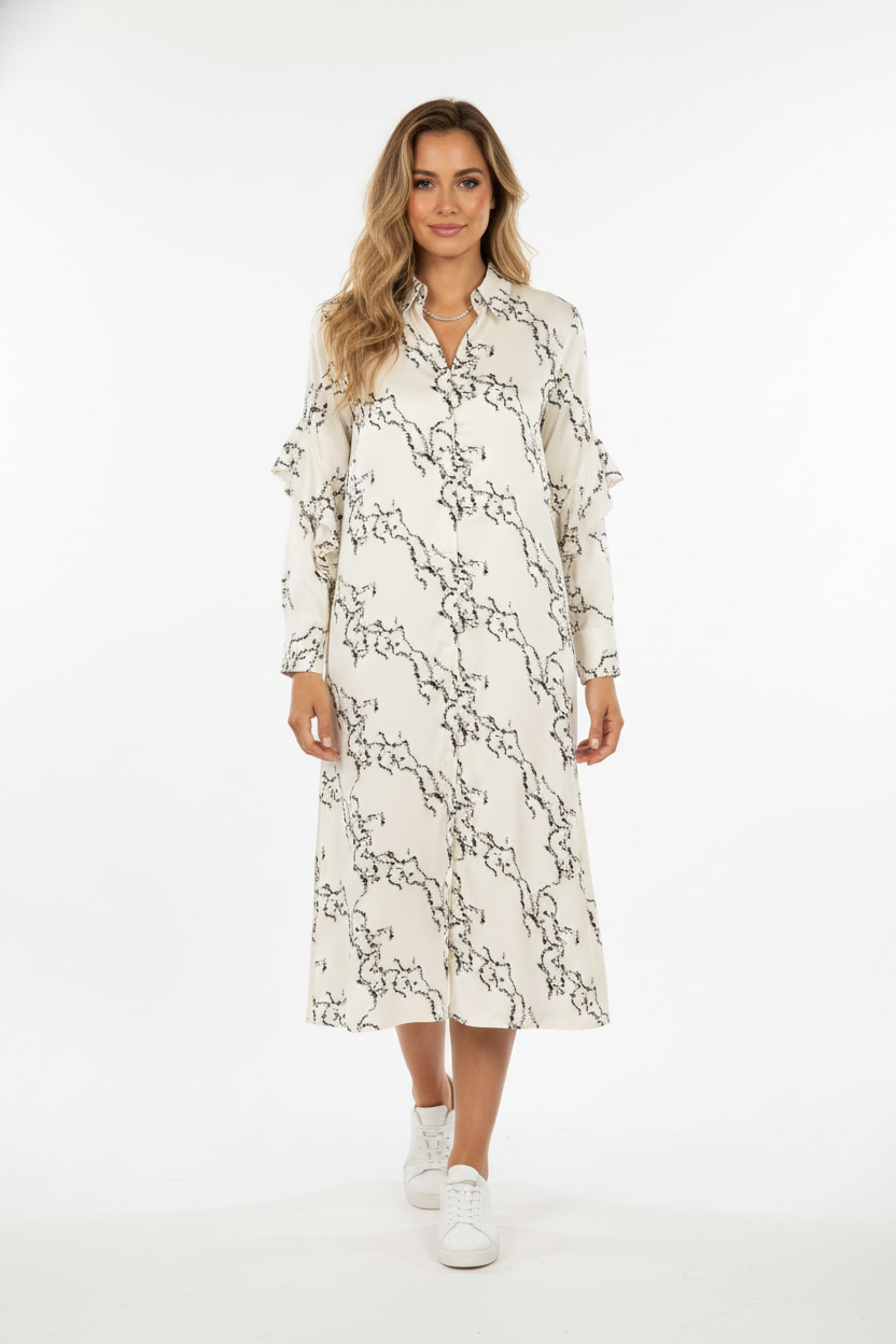 Model i cremehvid skjortekjole med grafisk linje-print – step sneakers