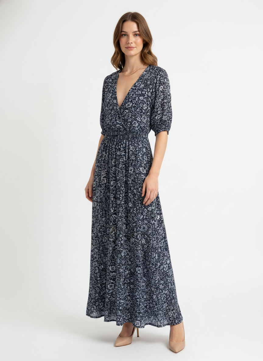 Model i mørkeblå maxikjole med småblomstret print – threequarter pumps
