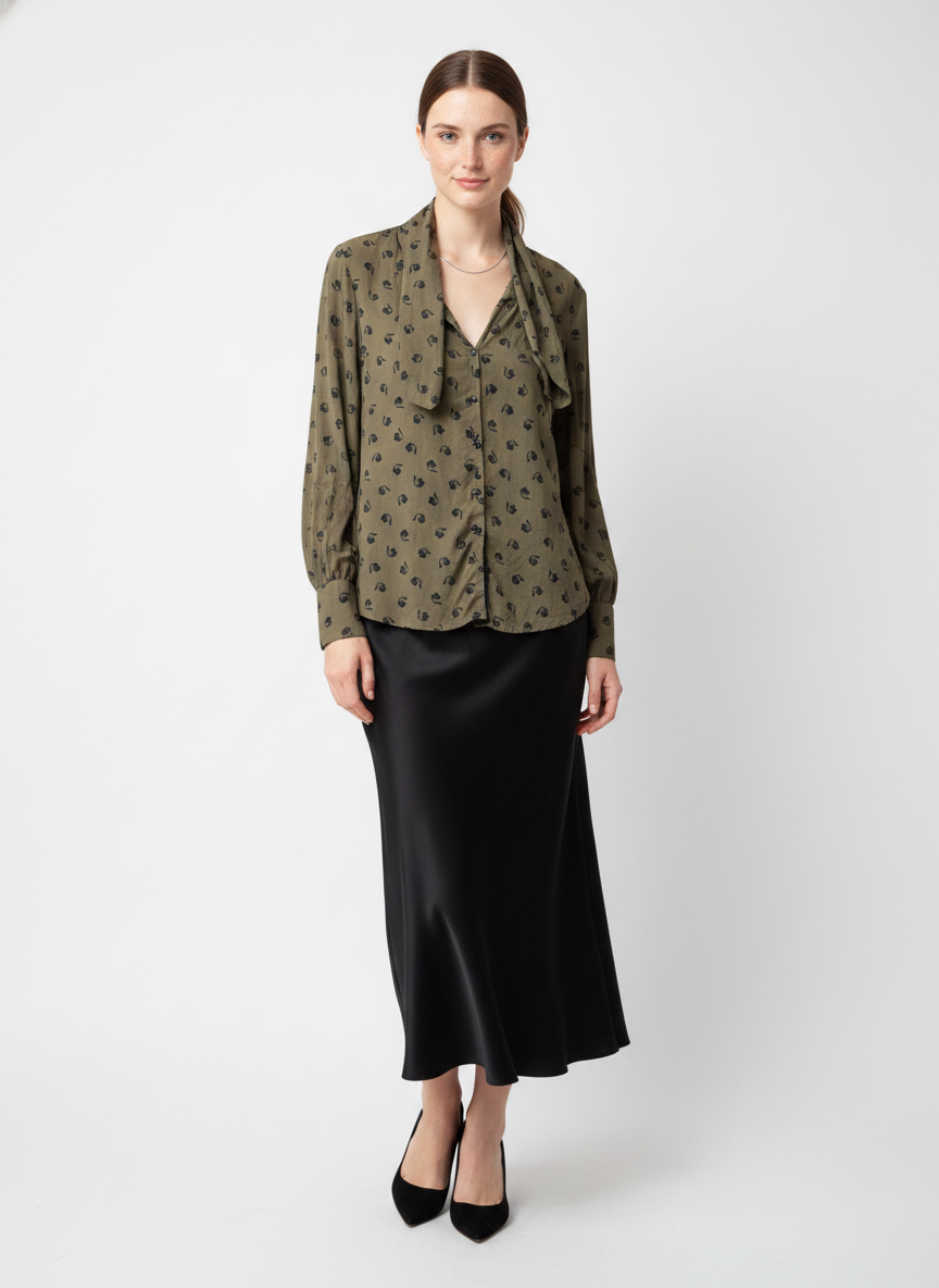 Model i olivengrøn skjorte med småprint og scarf-detalje – step skirt