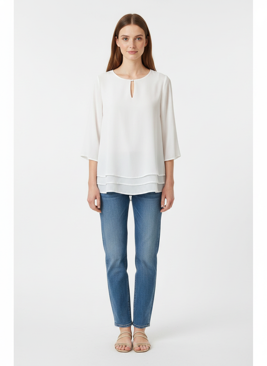 Model i hvid to-lags bluse med nøglehul-detalje – front jeans sandals
