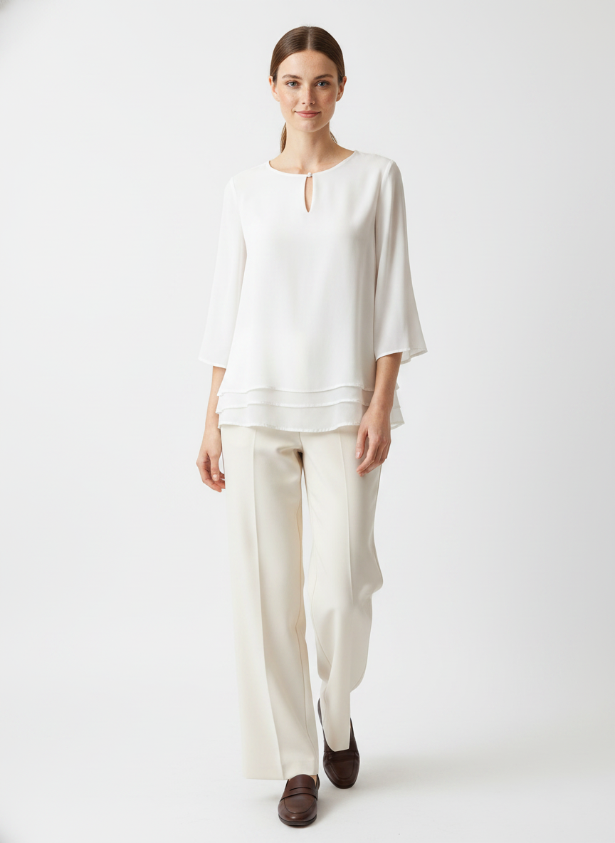 Model i hvid to-lags bluse med nøglehul-detalje – step trousers loafers
